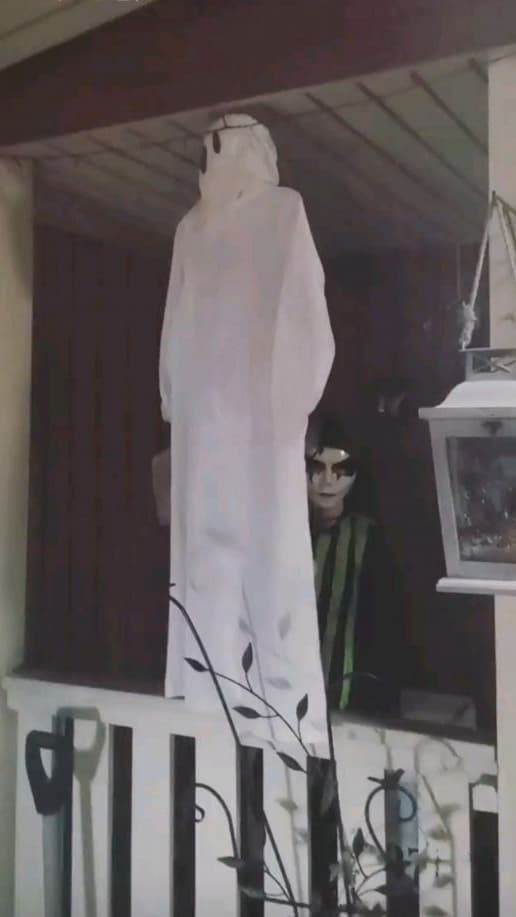 Kaksi ystäväperhettämme tuli ensimmäistä kertaa koronan tulon jälkeen meille kylään ja 11-v. poikamme oli erittäin innostunut Halloween-juhlista. Hänen johdollaan koristelimme sekä puutarhan, että kodin sisältä. Kuvassa lapsi kurkkaa Luciapuvusta tehdyn kummituksen takaa. Yllään hänellä on naamarin lisäksi itse suunnittelemansa ja pääosin toteuttamansa klovnin asu. Kuva: Musta Morsian