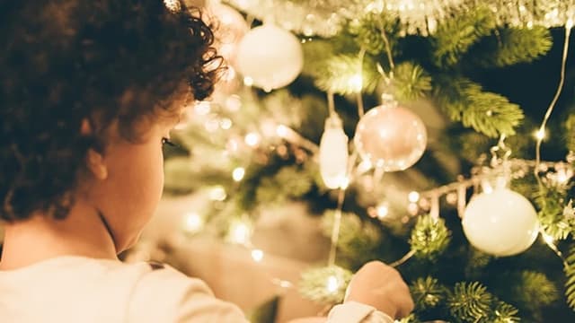Pieni lapsi koristelee joulukuusta