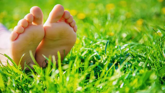 Ihminen makaamassa tuoreella nurmella