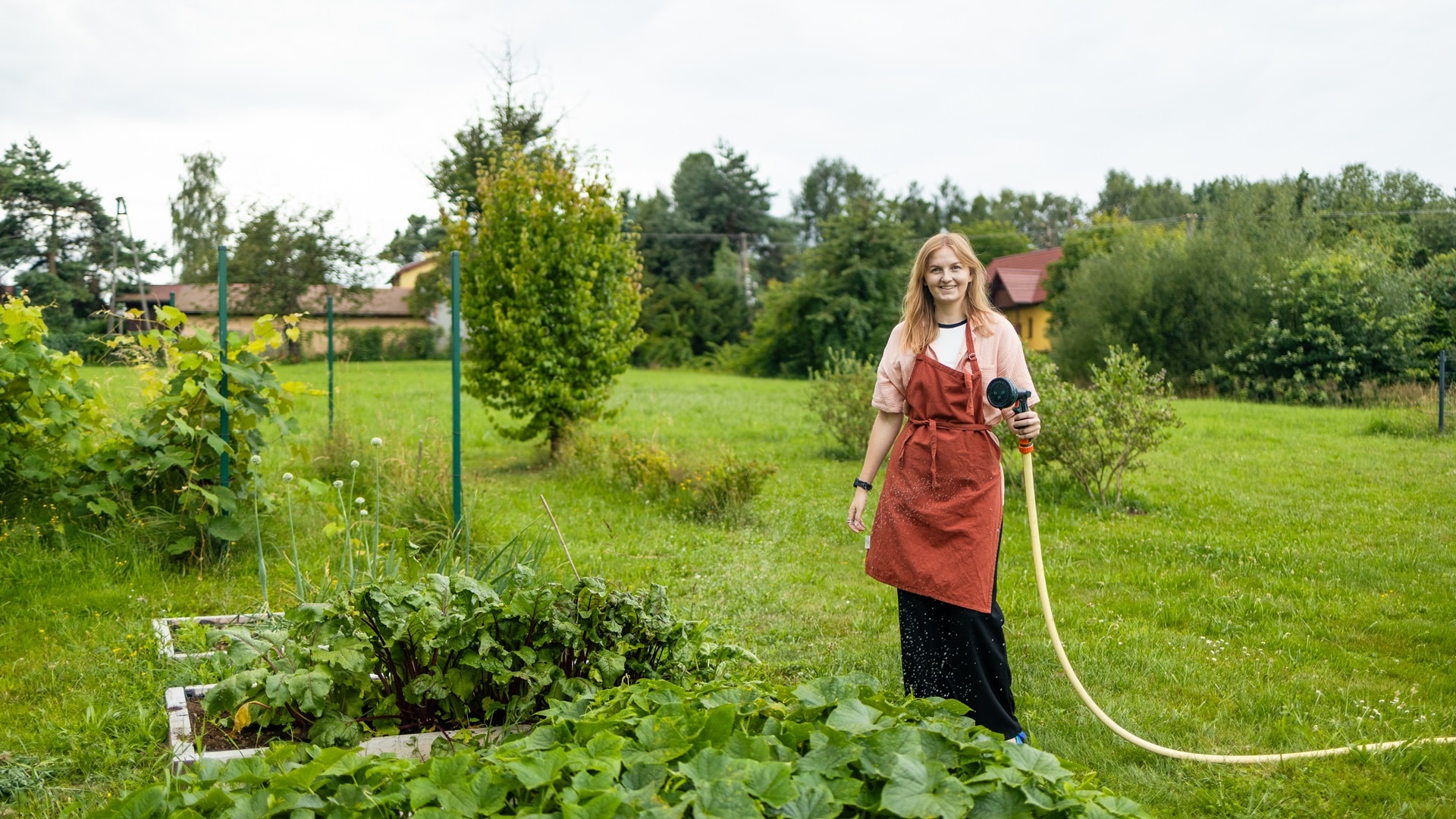 happy-woman-watering-fresh-plants-growing-at-home