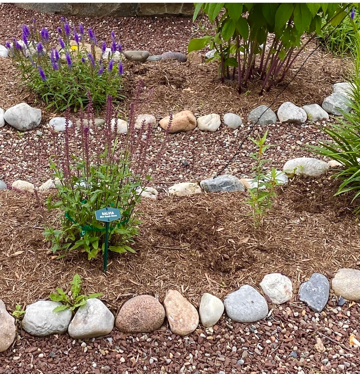 <p data-block-key="9gj7k">Luonnonkivistä rakennettu kukkapenkin reunus sulautuu osaksi rehevää puutarhaa ja kestää vuodesta toiseen. (Kuva: Envato)</p>