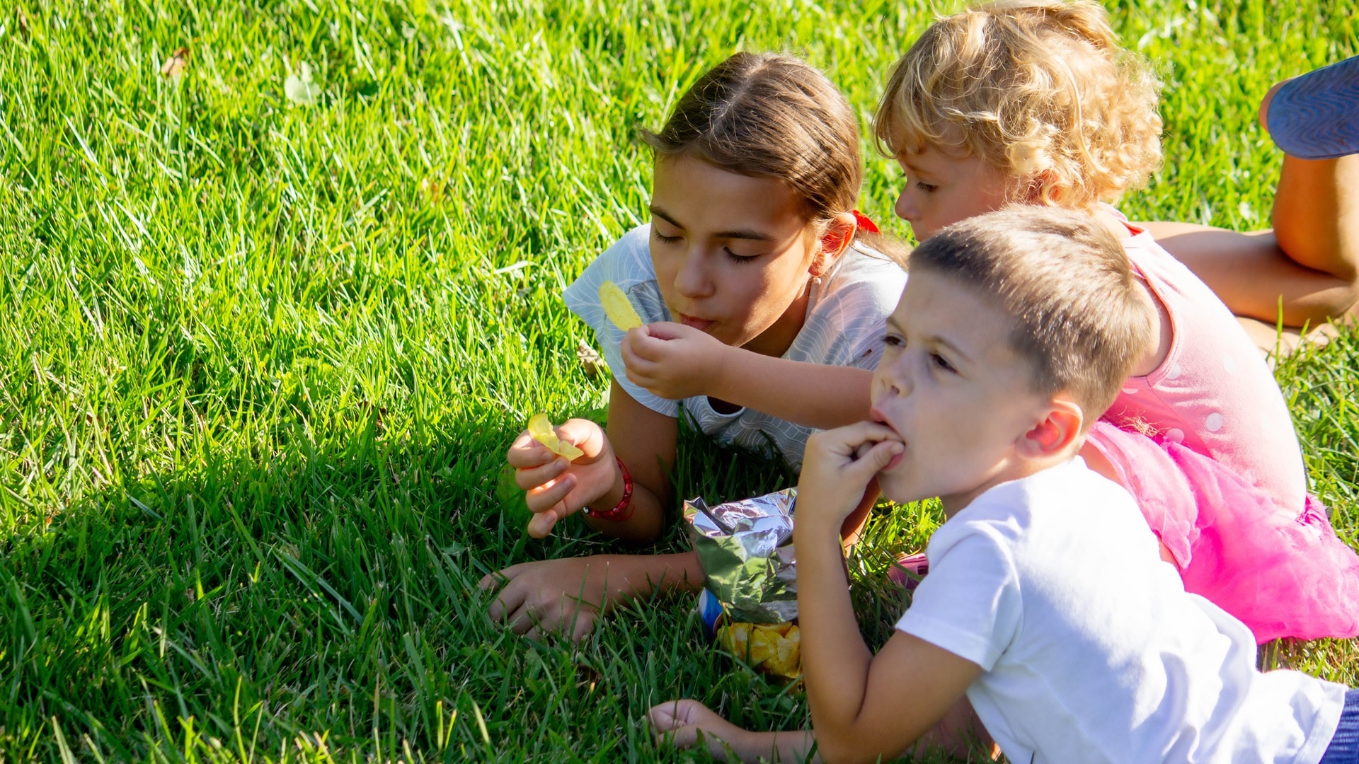 muokhappy-children-eating-chips-in-the-park-selective
